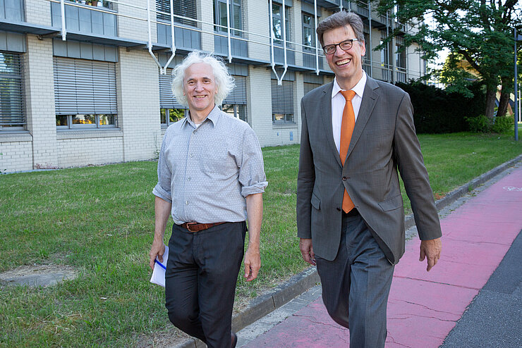 Josef Penninger and Christian Scherf walking down the crosswalk on the HZI campus.