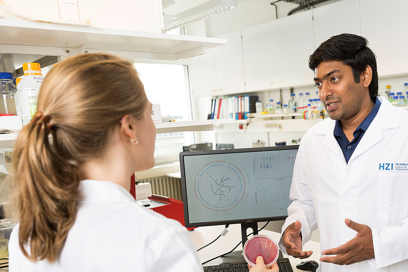 HZI researchers talk in the lab