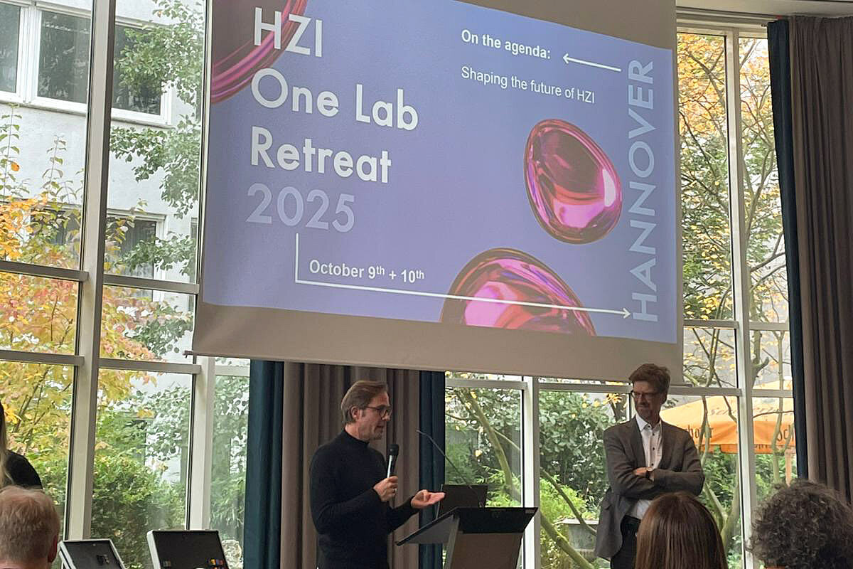 Two speakers in front of a presentation on a screen